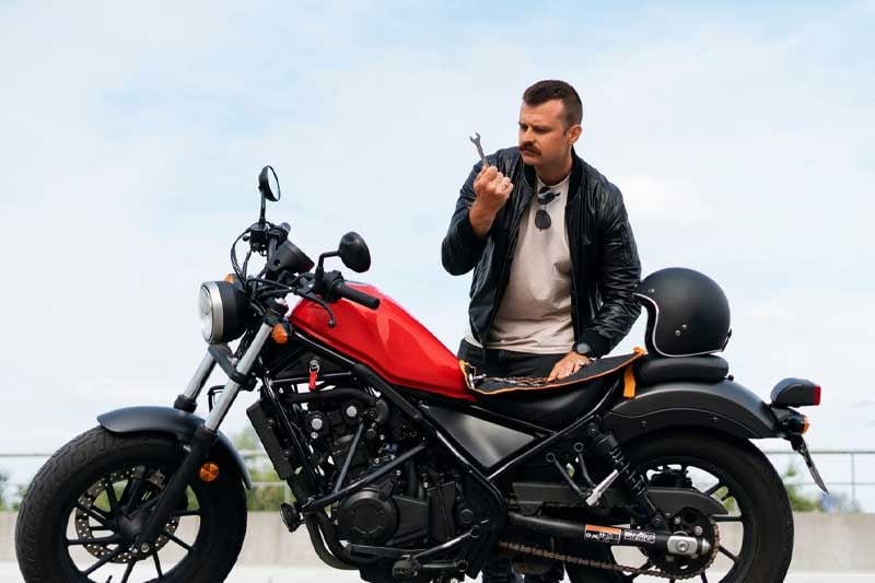 Motociclista ao lado de uma moto
